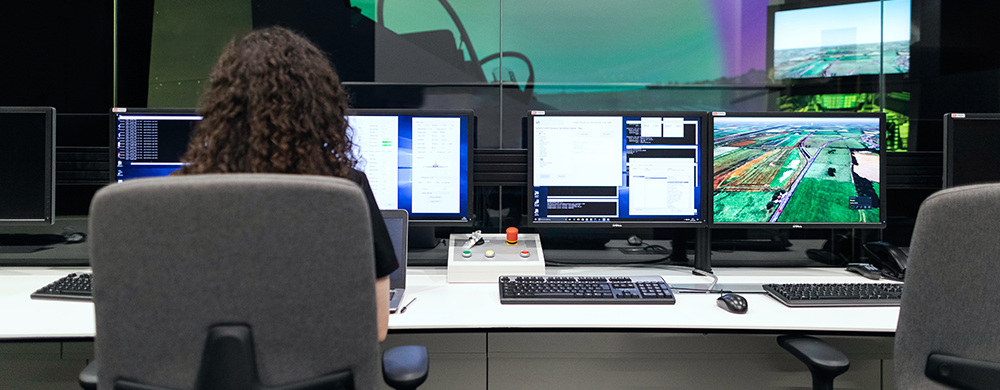 student at computer work station with multiple monitors