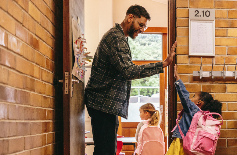 High five from a teacher to a young student