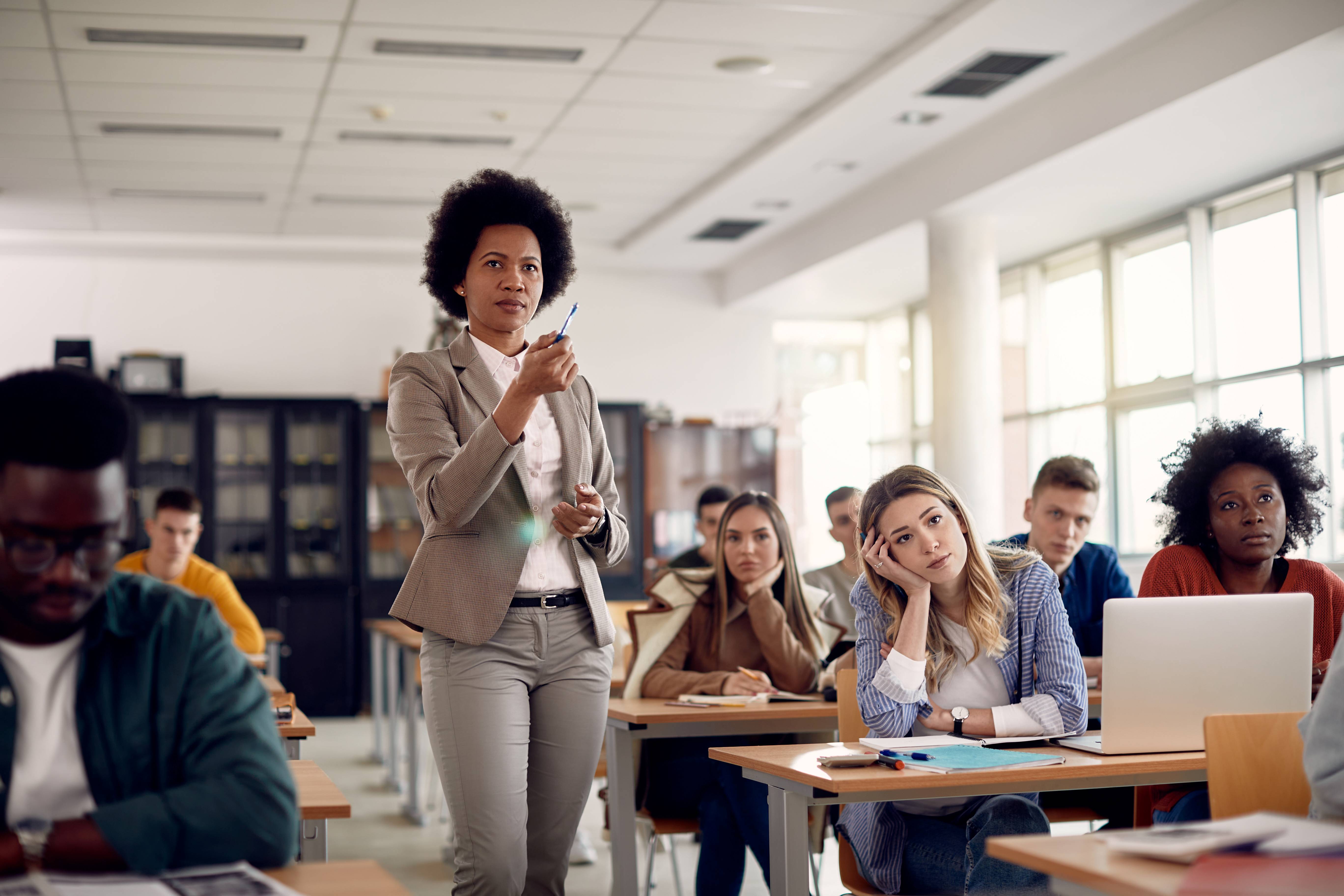 a teacher walks among students desks