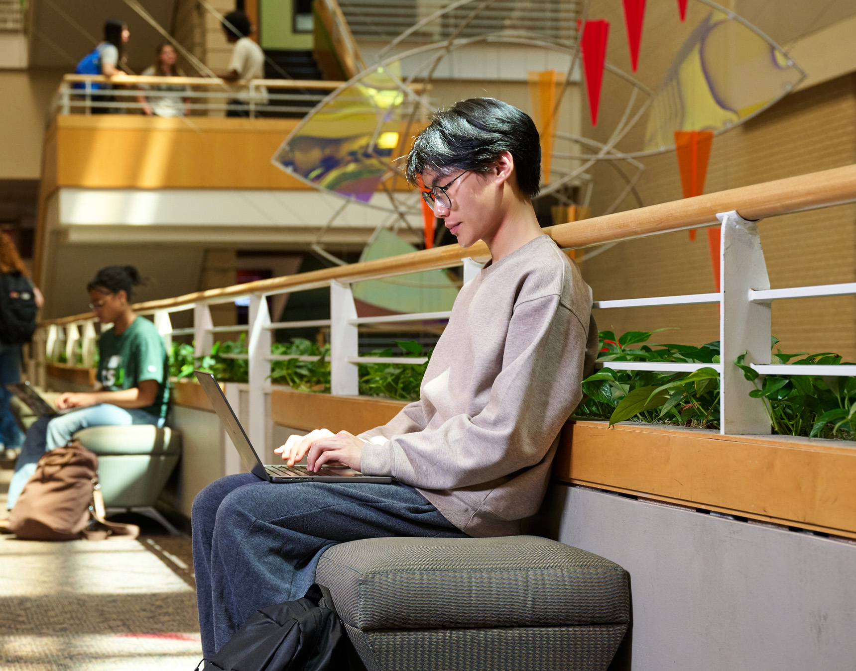 Student on computer inside campus building